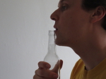 blaas over de opening van de fles heen