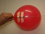 plak het rietje vlakbij het tuitje op de zijkant van de ballon met de stukjes plakband, zoals op het plaatje