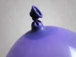 prik de satéprikker (die nog half in de ballon zit) naast het knoopje weer naar buiten