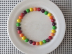 leg de skittles in een cirkel langs de rand op het bord